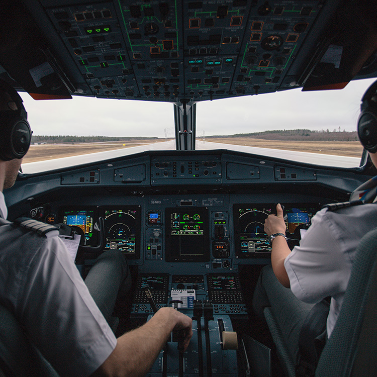 Pilot und Co-Pilot von hinten im Cockpit